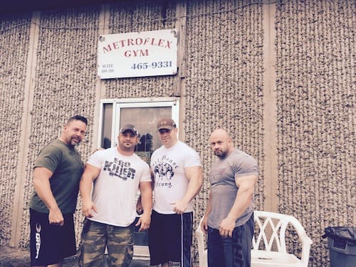 Four men in front of a gym